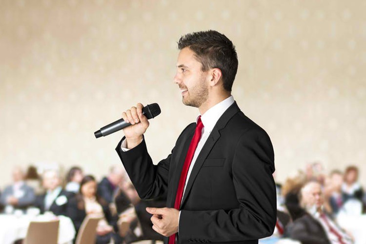Speaker with a microphone addressing guests at a corporate event - Snappy Photobooths