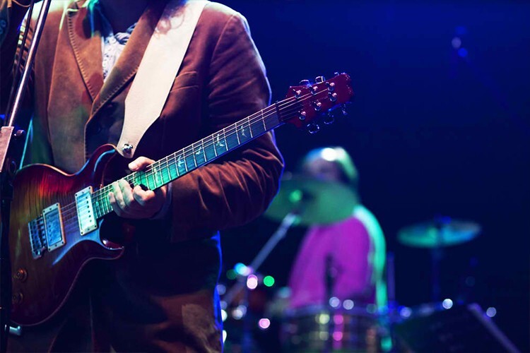 Musician performing guitar on stage at a fundraiser gala - Snappy Photobooths