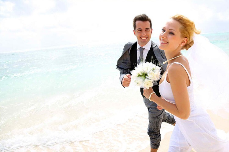 Bride and groom running along the beach - Snappy Photobooths