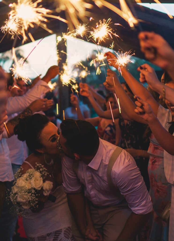Bride and groom kissing during a sparkler send-off at their wedding reception - Snappy Photobooths